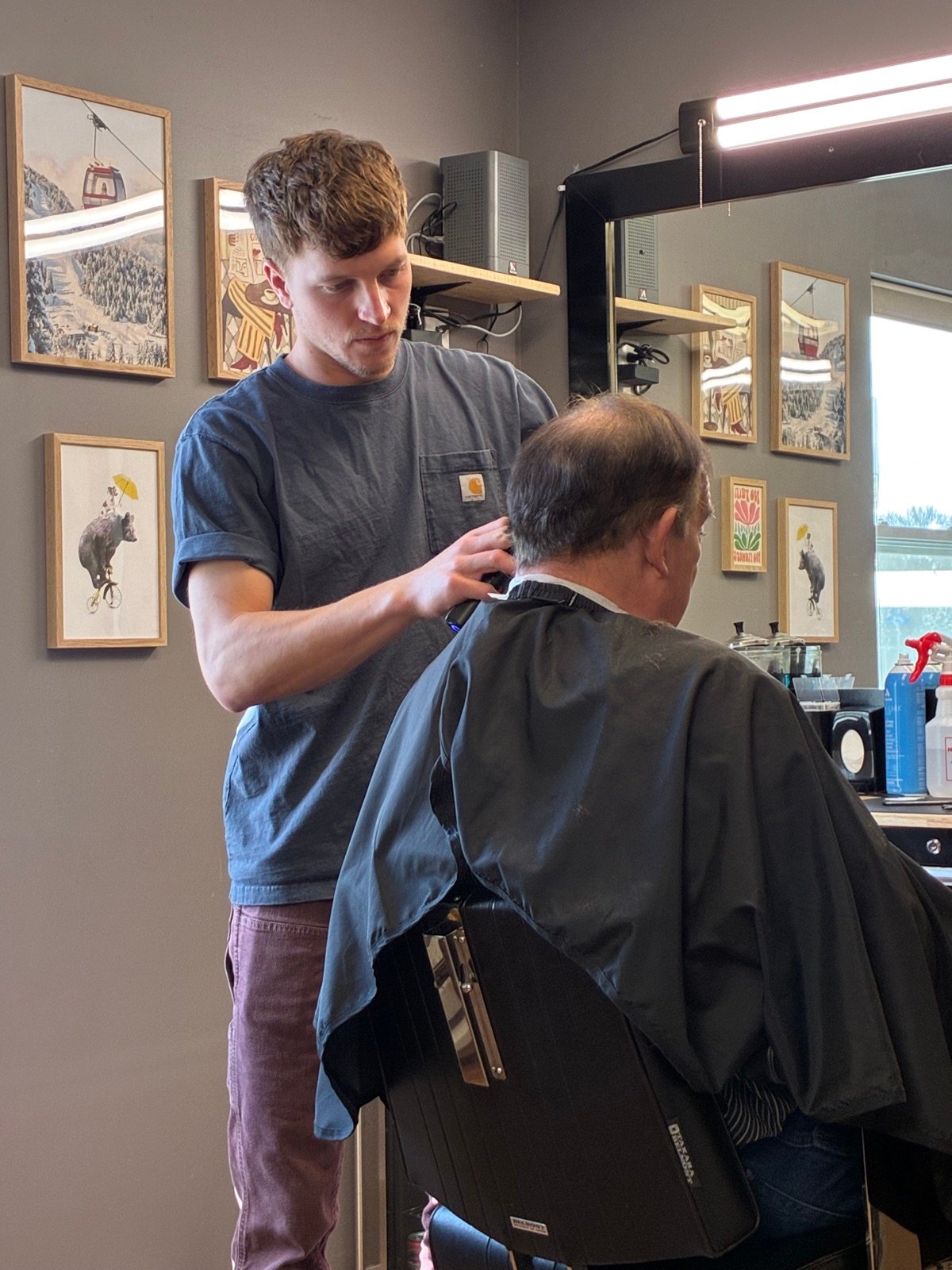 A barber at work at Slick & Steel